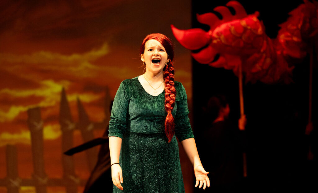 Red-headed Fiona singing powerfully in Breakout's production of Shrek JR.